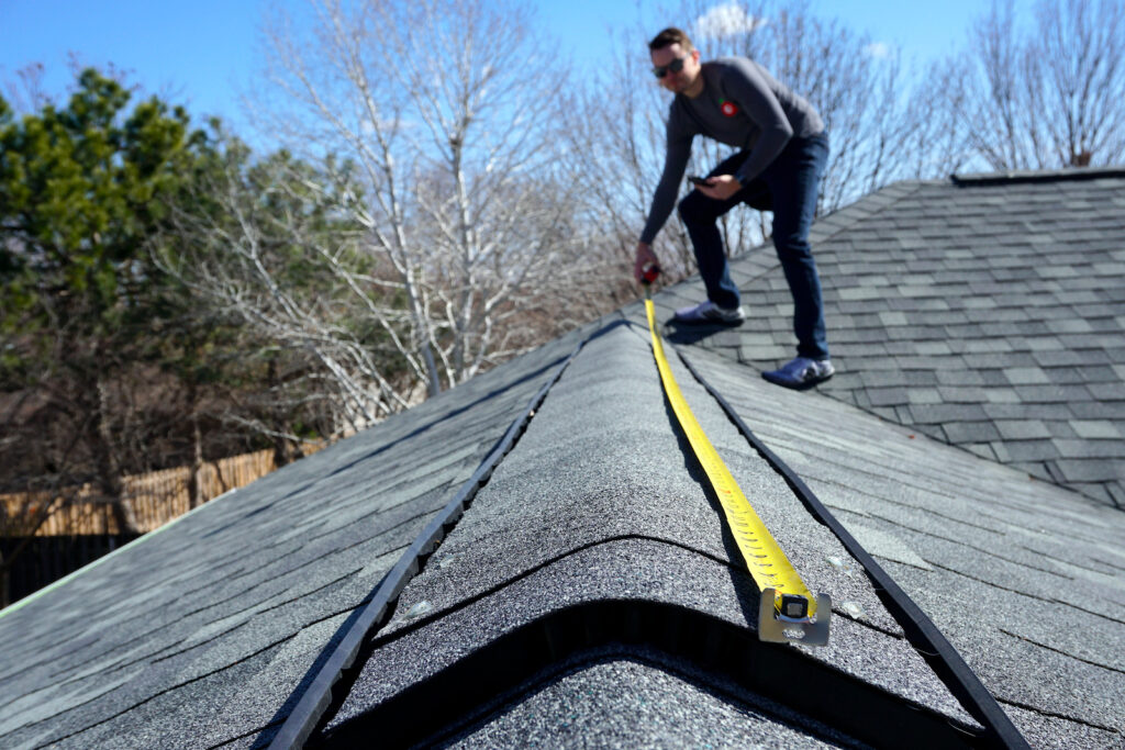 A man measuring the roof for re roofing In Vancouver