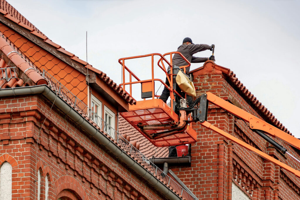 roofer performing maintenance on red bricks in Vancouver